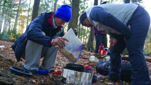 Students in the woods making food