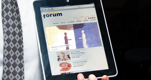 Image of a man holding an iPad displaying the education-forum.ca homepage.