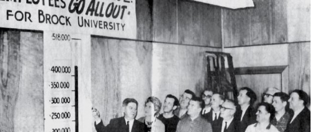 Vintage photo of McKinnon Industries employees admiring their fundraising thermometer chart.