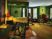 The photo of ancient bedroom furnishings that include bold green and red floral patterns.