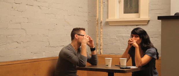 Photo of Attiya and Steve sitting at across from each other at a coffee shop.