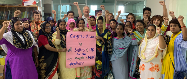 A photo of union leaders and the joint delegation standing in solidarity at the BCWS offices in Dhaka