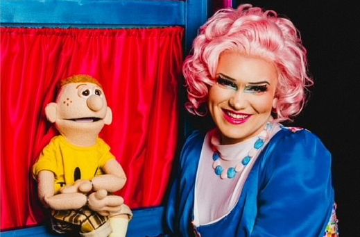 Betty Baker devant la scène d’un spectacle de marionnettes, tenant une marionnette.